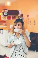 Young beautiful woman drinking hot cappuccino coffee at cafe.