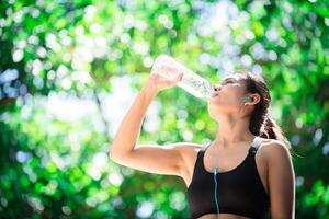 mujer joven practicando deportes mientras escucha música. tomar un descanso foto