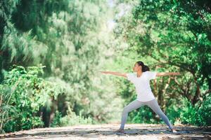 joven asiática haciendo yoga por la mañana en el parque. saludable foto