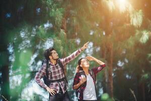 Young couple stop looking for something during hiking together. photo