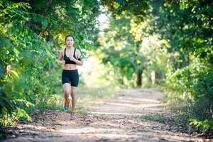 Young fitness woman running on a rural road. Sport woman running. photo