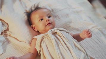 Close up infant smiling and lying on bed playing with mother video