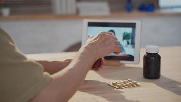 Senior patient using digital tablet for video call with male doctor