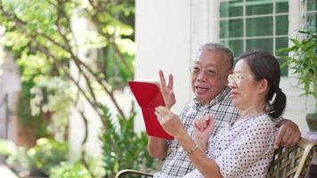 senior couple using tablet to talk with family via video call