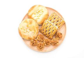 Pastel de toffee, pan con mahonesa de maíz y tartas de taro sobre fondo blanco.