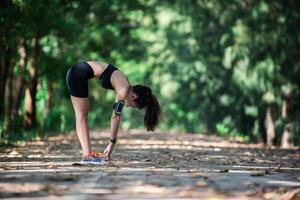 mujer joven fitness estirando las piernas antes de correr. foto