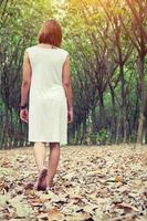 Sad woman walking alone in the forest feeling sad and lonely photo