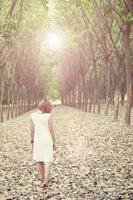 Sad woman walking alone in the forest feeling sad and lonely photo