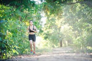 mujer joven fitness corriendo en un camino rural. mujer deportiva corriendo. foto
