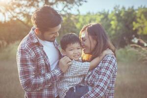 Happy young family spending time together outside in green nature park photo