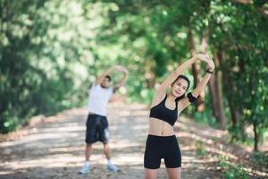 Man and woman stretching together at the park. photo