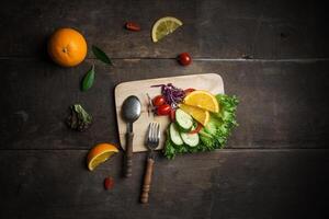 Fresh salad with slice of orange on a wooden background photo