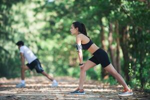 hombre y mujer estirando juntos en el parque. foto