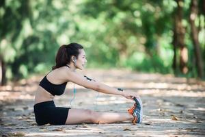 mujer joven fitness estirando las piernas antes de correr.