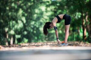 mujer joven fitness estirando las piernas antes de correr. foto