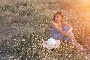 sexy hermosa mujer sentada en el campo de flores con tristeza y soledad foto