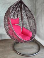 Hanging swing with stand and red soft pillow on the corner of the room photo