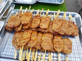 Cerdo a la parrilla tailandés vendido en el mercado de la calle peatonal foto