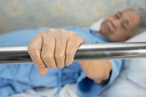 Paciente mujer mayor asiática acostarse manejar la cama de riel con esperanza