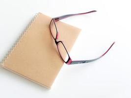 Blank page of a notebook and eyeglasses photo