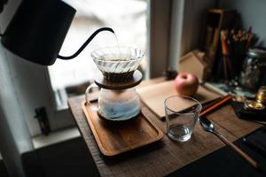 goteo de café en casa, vertiendo agua caliente sobre un goteo de café foto