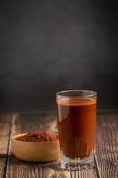 Thai milk tea and cocoa in bottle on wood table photo