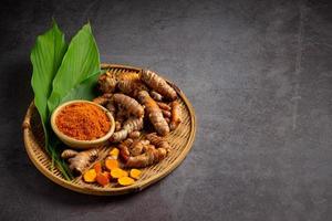 Tumeric rhizome with green leaf and turmeric powder photo