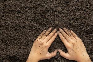 mano que sostiene el suelo negro para cultivar cultivos concepto del día mundial del suelo