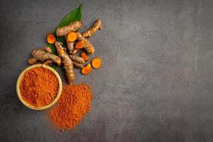 Tumeric rhizome with green leaf and turmeric powder photo