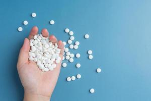 hand holding pills on colored background photo