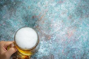 A glass of beer is placed on the wooden floor. photo