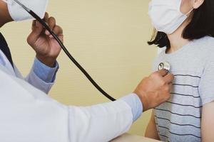 doctor using stethoscope to exam patient at hospital clinic photo