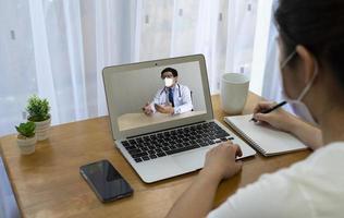Paciente que tiene fiebre y tos consultar a un médico asiático a través de una videollamada.