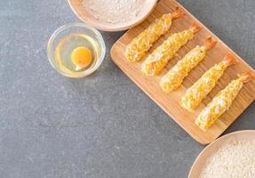 Batter-fried prawns on wood board with ingredients photo