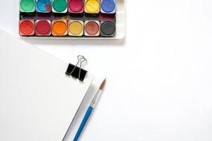 Water color paintbox and brushes on white background. Flat lay. photo