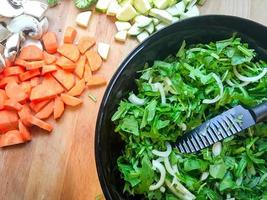 Zanahoria picada y ensalada en la mesa de la cocina foto