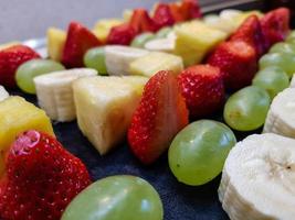 different fruits on a skewer covered with chocolate photo