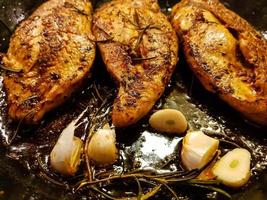 filled and marinated chicken breasts in a frying pan photo