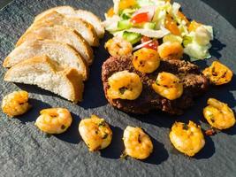Surf and turf fillet steak and white tiger prawns photo