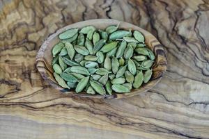 green cardamom on olive wood photo