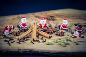 Santa Claus figures and christmas spices on olive wood photo