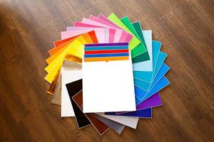 Montón trenzado de coloridas hojas de papel adhesivo de 12 x 12, caja aislada foto