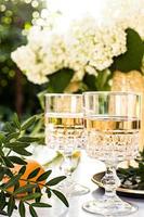 Rose wine in glasses on golden bottles with flowers and fruits photo