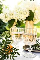 Rose wine in glasses on golden bottles with flowers and fruits photo