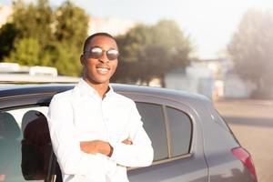 feliz afroamericano junto a un coche en el verano foto