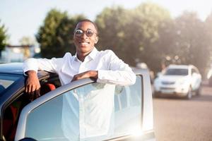 happy african american next to a car in the summer photo