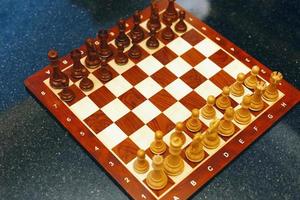 Foto de tablero de ajedrez sobre mesa de piedra negra listo para el juego