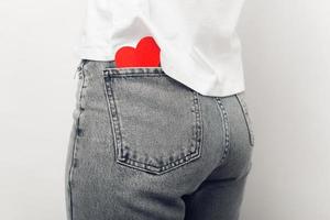 Cerrar foto de corazón en forma de papel rojo en pantalones de bolsillo trasero