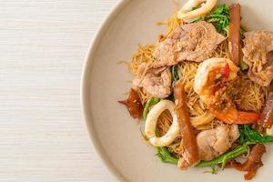 Fideos de arroz salteados y mimosa de agua con carne mixta foto