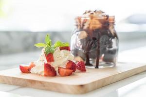 Chocolate brownies with vanilla ice cream, whip cream, and strawberry photo